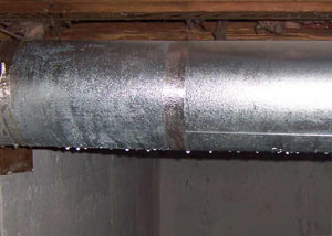 condensation collecting on an HVAC vent in a humid New Westminster basement