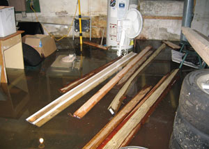 A severely flooding basement in Maple Ridge, with lumber and personal items floating in a foot of water